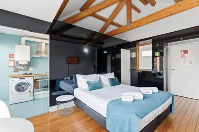a large bedroom with two beds and a kitchen at GuestReady - Cosy studio in the heart of Porto in Porto