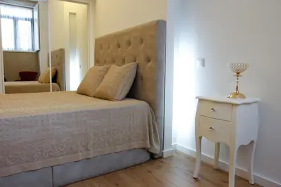 a bedroom with a large bed and a white nightstand at Lux Downtown in Porto