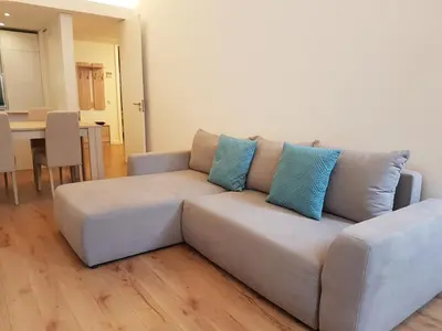 a couch with blue pillows sitting in a living room at Lux Downtown in Porto