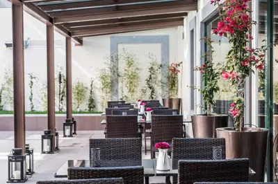 a row of chairs on a patio with flowers at Vila Gale Porto Ribeira in Porto