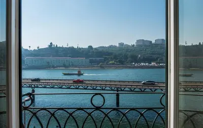 a view of a river and a bridge from a window at Vila Gale Porto Ribeira in Porto