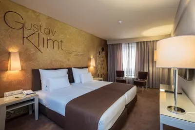 a hotel room with a bed and a sign on the wall at Vila Gale Porto Ribeira in Porto