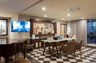 a dining room with a tv and a table and chairs at Vila Gale Porto Ribeira in Porto