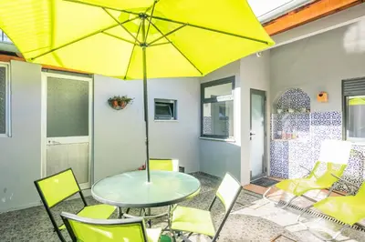 a table and chairs with a yellow umbrella on a patio at Apartamento Garden Avenue in Porto