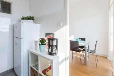a kitchen with a table and a white refrigerator at Apartment Cozy 4YOU in Porto