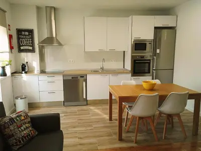 a kitchen with a wooden table and a dining room at Always Porto in Vila Nova de Gaia