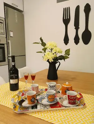 a table with cups and plates and a bottle of wine at Always Porto in Vila Nova de Gaia