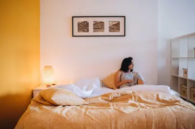 a woman sitting on a bed in a bedroom at Budget-Friendly Studio with Balcony in Rosario in Porto