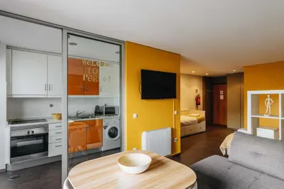 a living room with a table and a kitchen at Budget-Friendly Studio with Balcony in Rosario in Porto