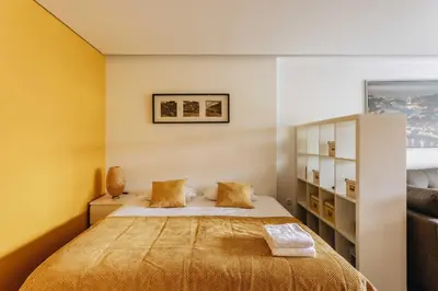 a bedroom with a bed with yellow walls at Budget-Friendly Studio with Balcony in Rosario in Porto