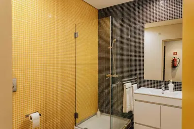 a bathroom with a glass shower and a sink at Budget-Friendly Studio with Balcony in Rosario in Porto
