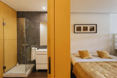 a bathroom with a bed and a shower and a sink at Budget-Friendly Studio with Balcony in Rosario in Porto