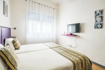 a bedroom with a bed and a tv on the wall at Apartamento Purple Room in Porto