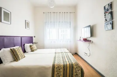 a bedroom with two beds and a window at Apartamento Purple Room in Porto