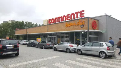 a parking lot with cars parked in front of a store at Apartamento Purple Room in Porto