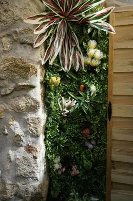 a stone wall with flowers and plants on it at The Blue and White Porto House in Porto