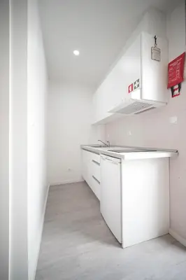 a white kitchen with white cabinets and a counter at The Blue and White Porto House in Porto