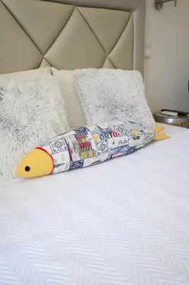 a long pillow on top of a bed at The Blue and White Porto House in Porto