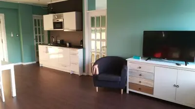 a living room with a television and a chair and a kitchen at Porto Downtown Main Str (S.Catarina) + Free Park in Porto