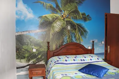 a bedroom with a bed with a palm tree mural at Pensão França in Porto