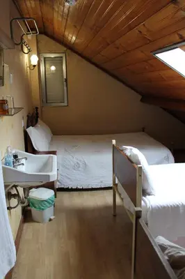 a bedroom with a bed and a sink in a room at Pensão França in Porto