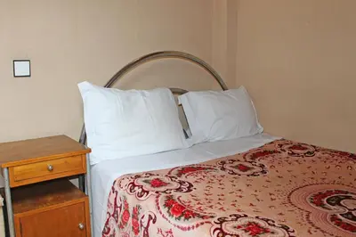a bed with white pillows and a wooden table at Pensão França in Porto