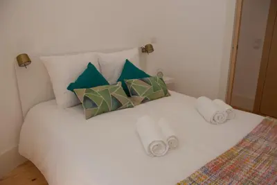 a white bed with towels and pillows on it at OportoView Alegria Apartment in Porto