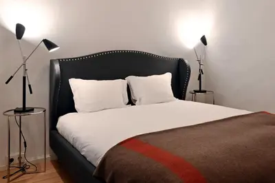 a bedroom with a bed with a black headboard and two lamps at Oporto Chic&Cozy - Ribeira in Porto