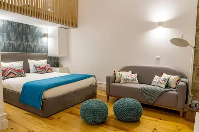 a bedroom with a bed and a couch and a chair at Formosa 178 by Guestify in Porto