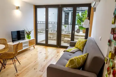 a living room with a couch and a television and a table at Formosa 178 by Guestify in Porto
