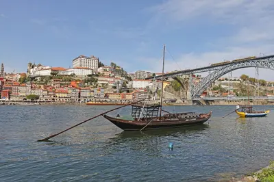 a boat in the water in front of a bridge at FLH Porto Bright Flat in Porto