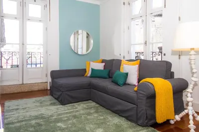 a living room with a gray couch with colorful pillows at Liiiving in Porto | Ribeira Boutique Apartment in Porto
