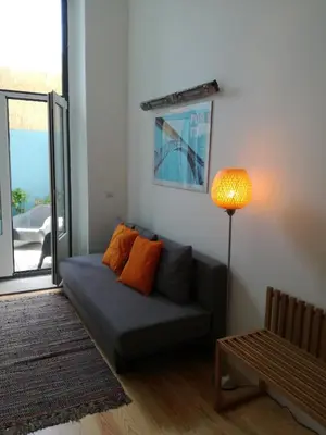 a living room with a blue couch and a large window at DL 205 in Porto