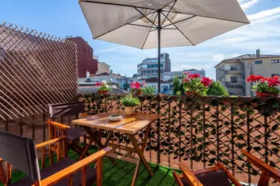 a table and chairs with an umbrella on a balcony at Covelo Park Apartment in Porto