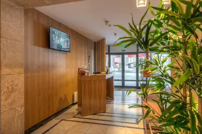a lobby with potted plants and a reception desk at Spot Family Apartments in Porto