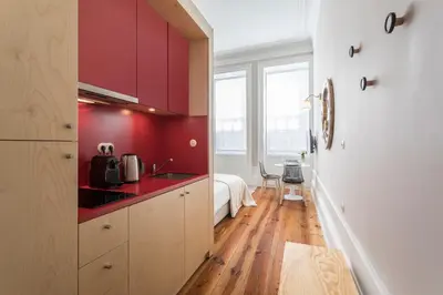 a kitchen with red walls and wooden floors at Ribeira Historic Apartments in Porto