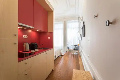 a kitchen with red walls and wooden cabinets at Ribeira Historic Apartments in Porto