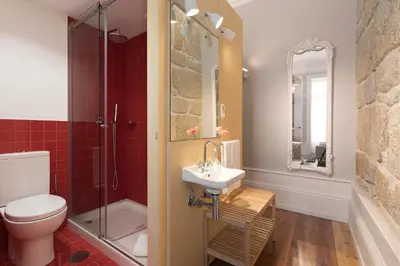a bathroom with a toilet and a sink and a shower at Ribeira Historic Apartments in Porto