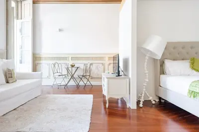 a white bedroom with a white bed and a table at Get a Unique and Luxury Flat in Porto