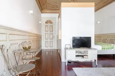 a bedroom with a bed and a table and a television at Get a Unique and Luxury Flat in Porto