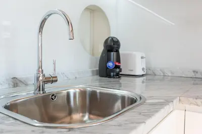 a kitchen counter with a sink and a appliance at Sá de Noronha Mezzanine w Terrace in Porto