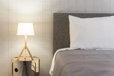 a bed with a white pillow and a table with a lamp at Sá de Noronha Mezzanine w Terrace in Porto