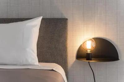 a lamp next to a bed with a white pillow at Sá de Noronha Mezzanine w Terrace in Porto