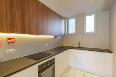 a kitchen with white cabinets and a sink at N Apartments - Bolhão in Porto