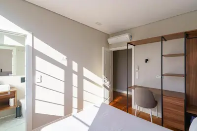 a bedroom with a bed and a desk and a chair at N Apartments - Bolhão in Porto