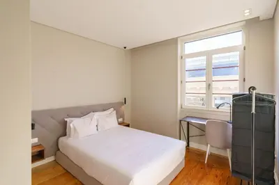 a bedroom with a bed and a desk and a window at N Apartments - Bolhão in Porto