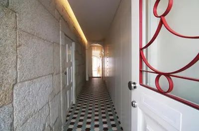 a hallway with a red door and a black and white tile floor at HM - Pinheiro Cosy Apartment in Porto