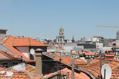 a view of a city with roofs and a clock tower at Amazing Penthouse Apartment in historic Porto in Porto