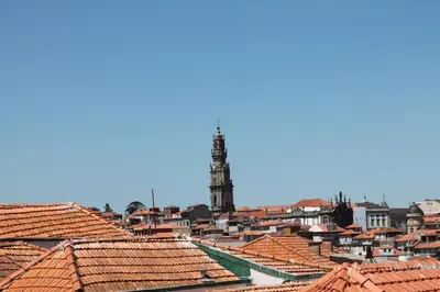 a view of roofs of a city with a clock tower at Amazing Penthouse Apartment in historic Porto in Porto
