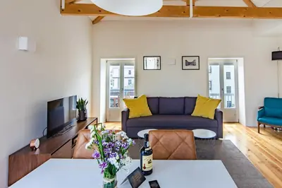 a living room with a couch and a tv at Amazing Penthouse Apartment in historic Porto in Porto